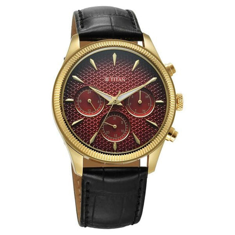 a gold watch with a red face and black leather strap