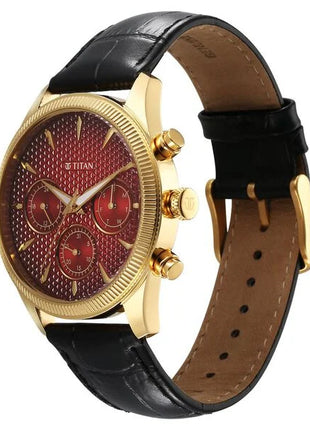 a gold watch with a red dial on a black leather strap