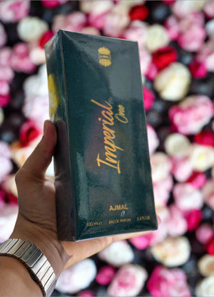 a person holding up a book in front of a wall of flowers